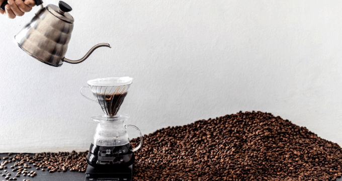 Manual pour over coffee maker with coffee beans in the background