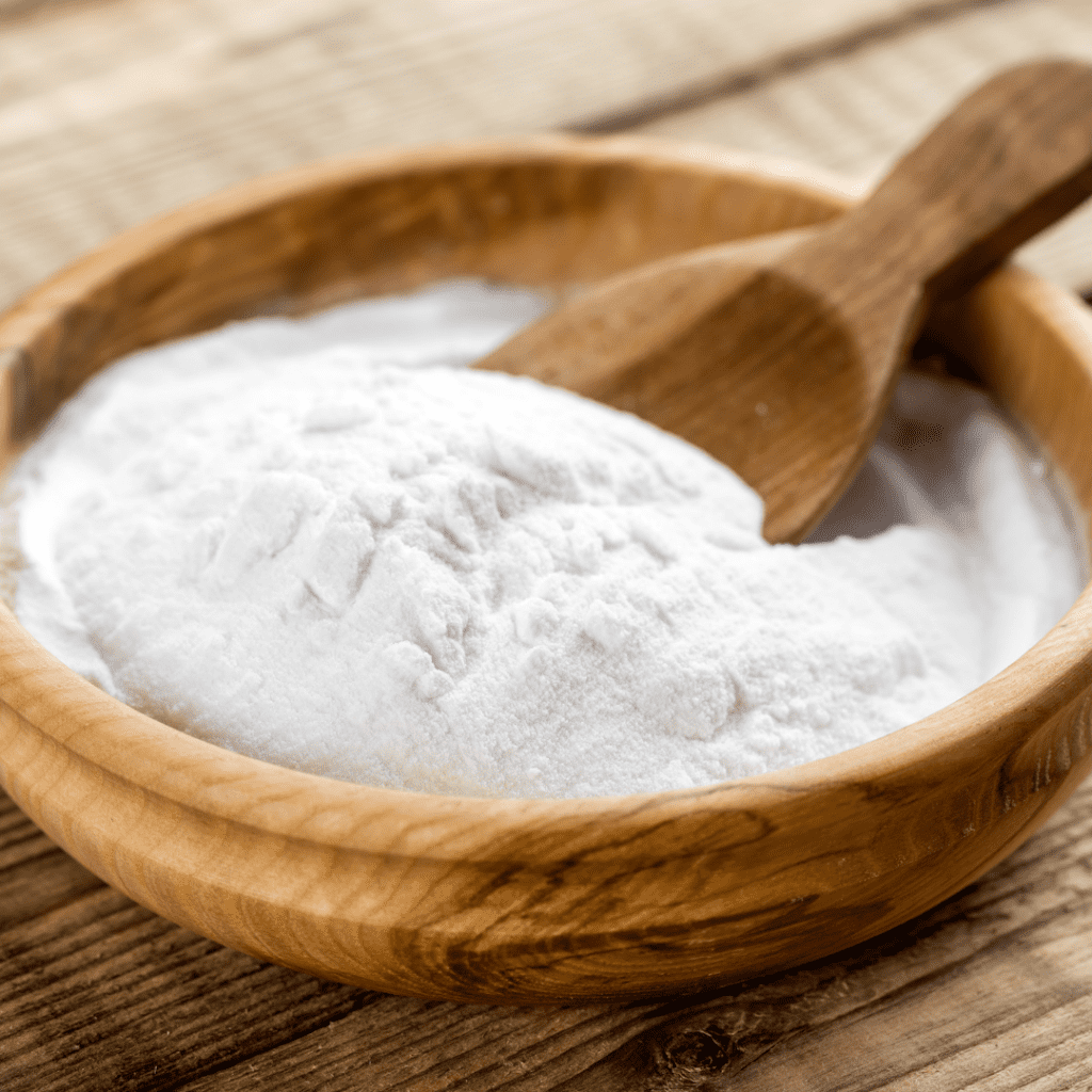 baking soda in a wooden bowl with a small wooden spoon